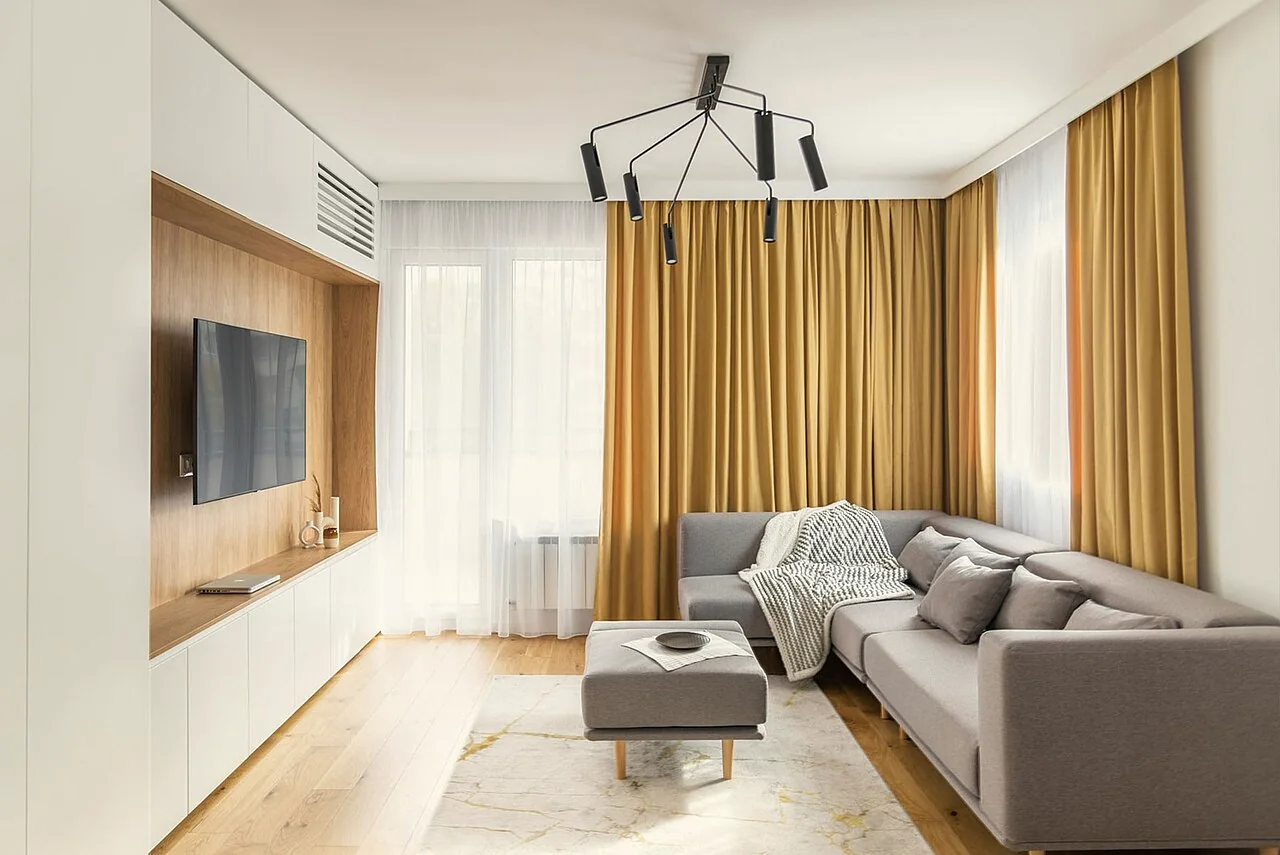 Heller moderner Wohnraum mit Sofa, Holzboden und großen Fenstern